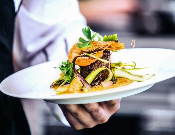 a man holding a gourmet dinner plate