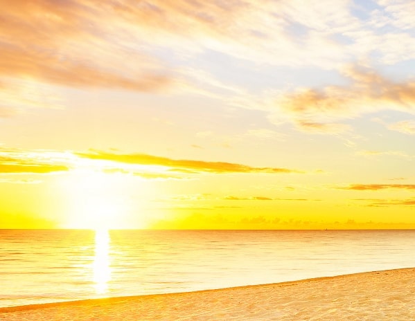 a bright yellow sunrise on the beach